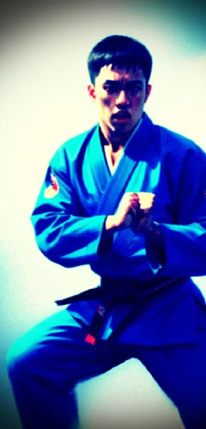 Martial artist in blue uniform striking a fierce pose.