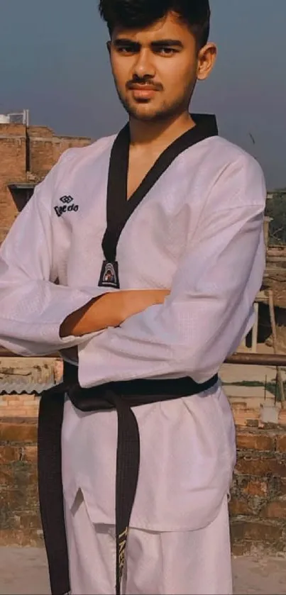 Martial artist posing outdoors in uniform.