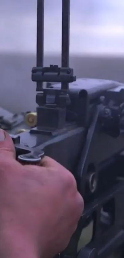 Close-up of a hand adjusting intricate metal machinery on a gray background.