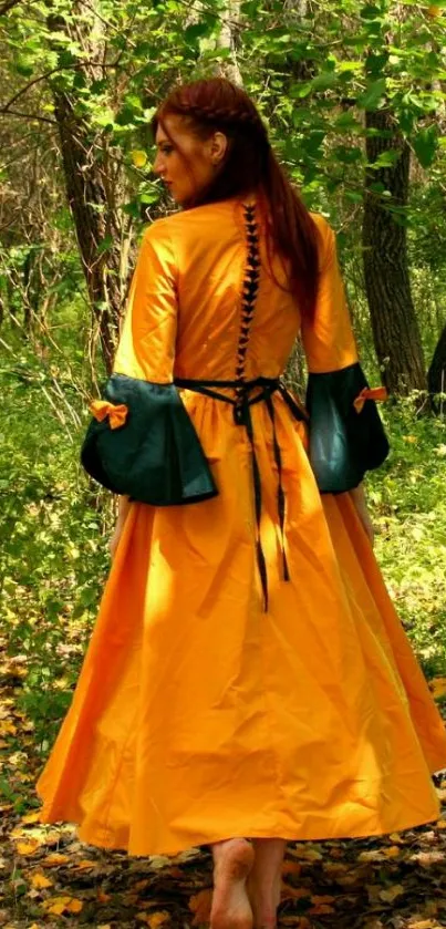 Woman in an orange medieval dress walks through lush green forest.