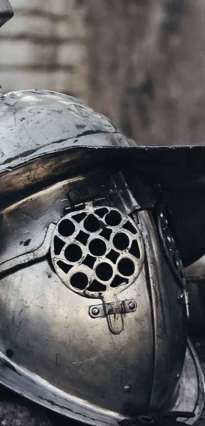 Close-up of medieval gladiator helmet on stone surface.