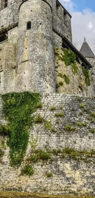 Medieval stone castle with moss-covered walls under a blue sky.