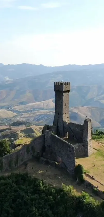 Medieval stone tower with mountain backdrop.