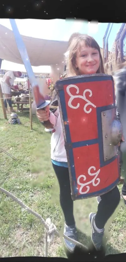 Child in medieval costume with sword and shield at a reenactment fair.