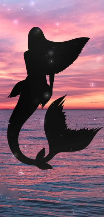 Silhouette of a mermaid at sunset with a pink ocean backdrop.