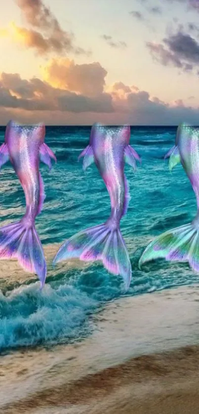 Three mermaid tails over a sunset-lit ocean waves on a beach.