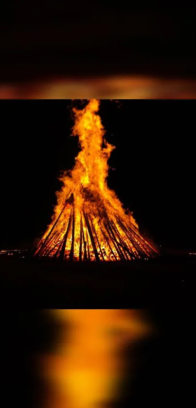 Bonfire wallpaper with bright orange flames in the dark night backdrop.