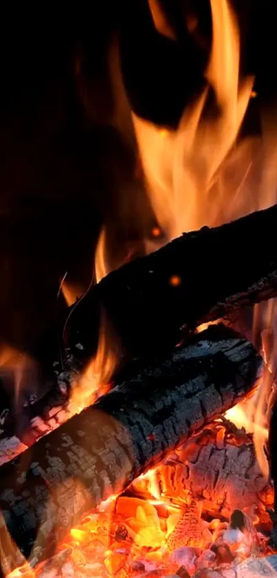 Mobile wallpaper of flickering fire flames with glowing embers and burning wood.