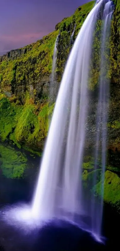 Stunning waterfall cascading over lush green cliffs at sunset.