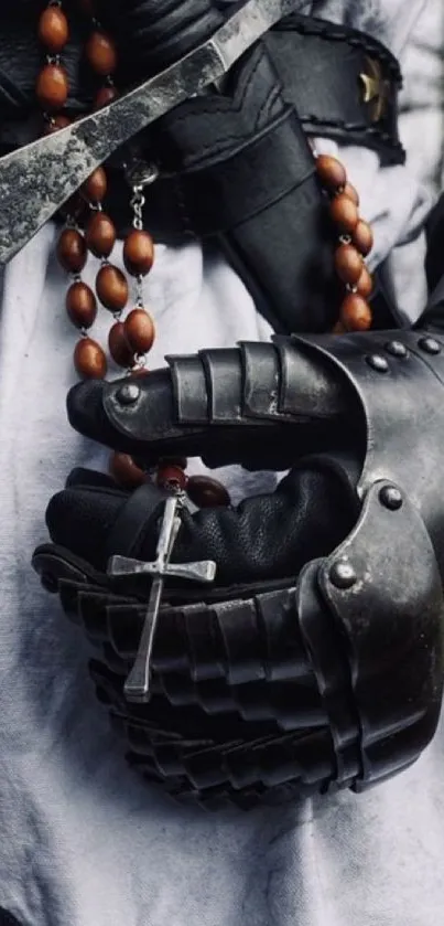 Metal gauntlet holding a rosary, medieval theme.