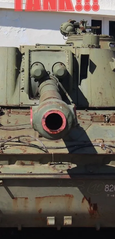 Front view of a military tank against a building backdrop.