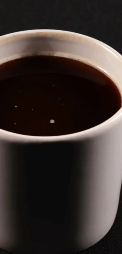 Minimalist dark coffee in white mug on black background wallpaper.