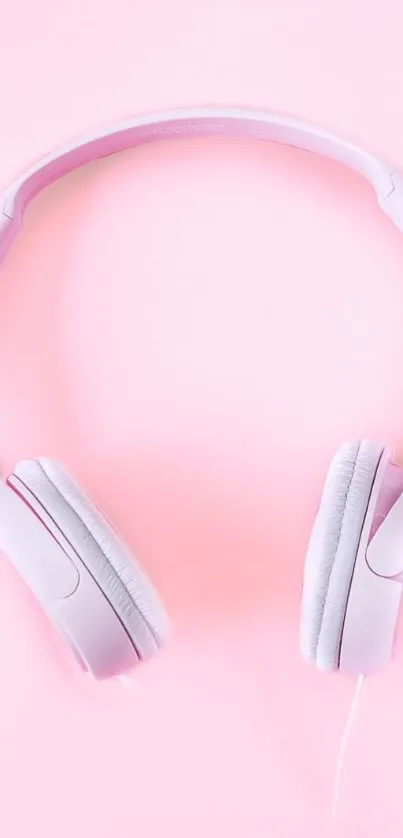 Pink headphones on soft pink background, minimalist wallpaper.