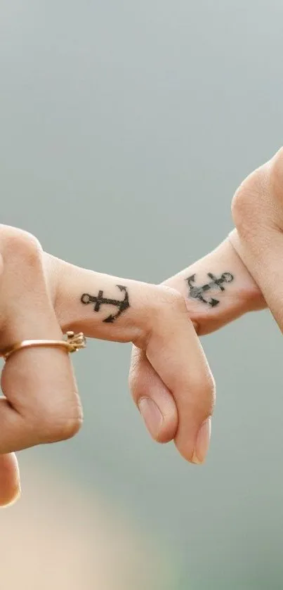 Minimalist anchor tattoos on fingers, symbolizing stability.