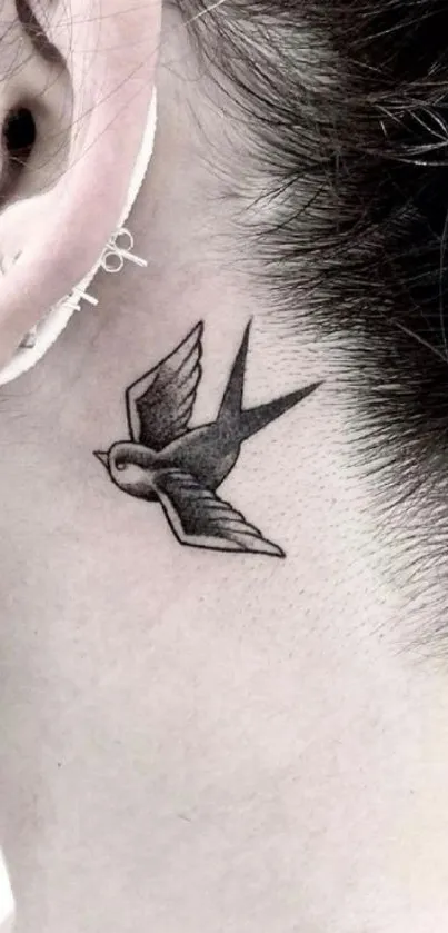 Minimalist bird tattoo on neck with light gray tones.