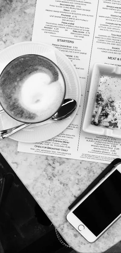 Black and white coffee and phone scene on a marble table.