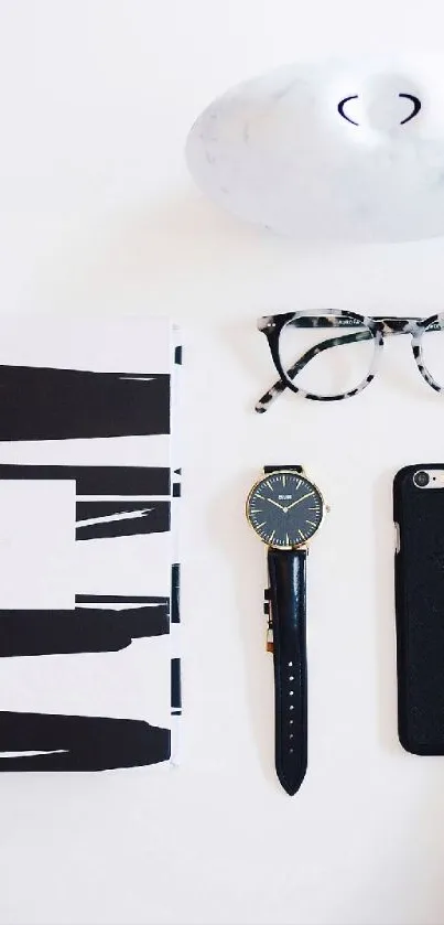 Minimalist flat lay with black and white essentials, including a watch and smartphone.