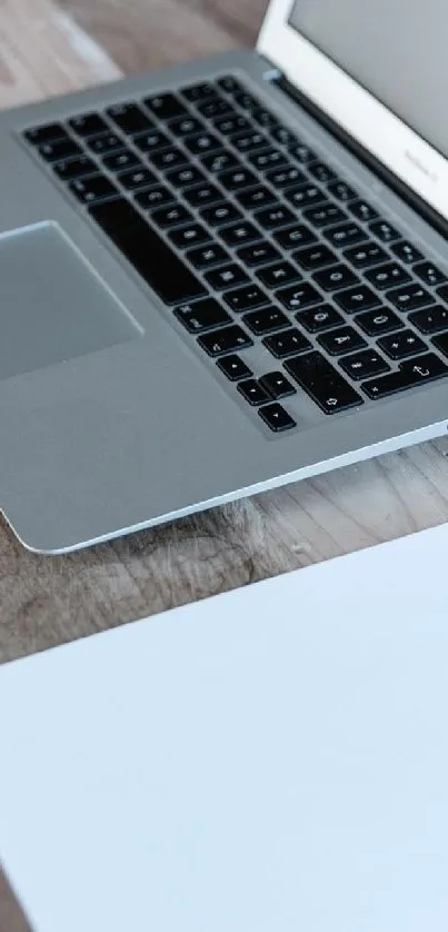 Minimalist laptop on wooden desk setup.
