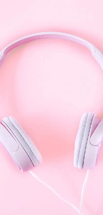 Minimalist pink headphones on soft background.