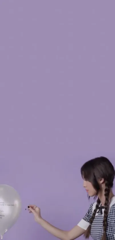 Minimalist wallpaper with a balloon and a person against a pastel purple background.