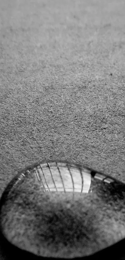 Black and white wallpaper with a raindrop on a textured surface.