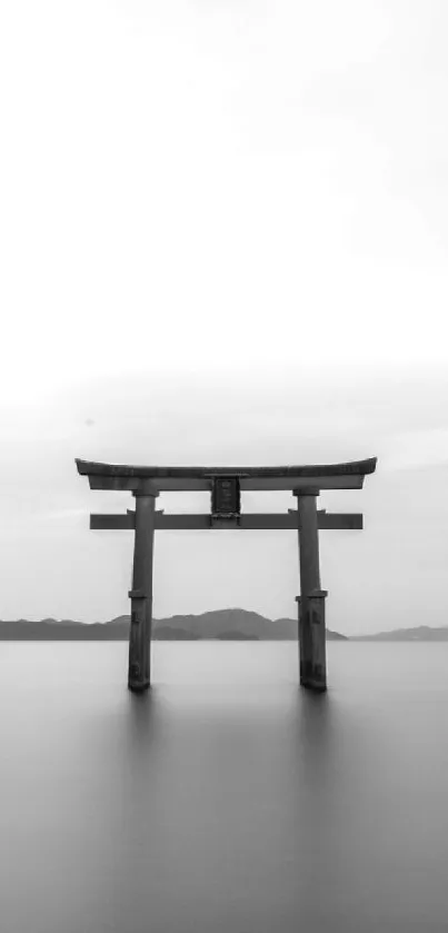 Minimalist Torii gate over calm waters in grayscale design.