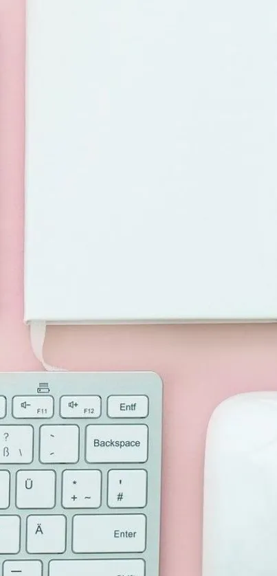 Minimalist workspace with pink accents, keyboard and notebook.