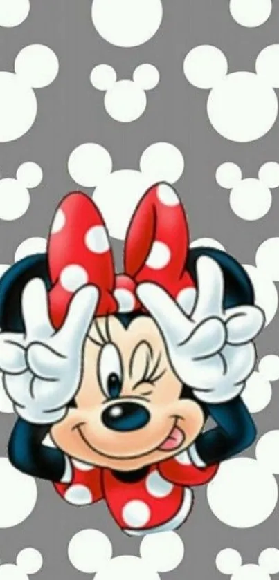 Minnie Mouse with red bow and playful pose on gray background with Mickey shapes.