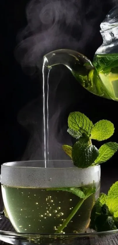 Hot mint tea being poured into a glass cup with steam rising.