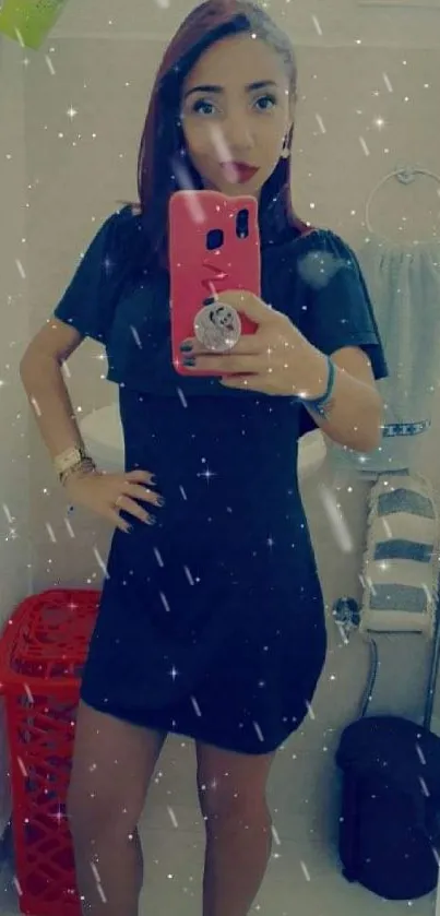 Woman in black dress taking a glittery mirror selfie.