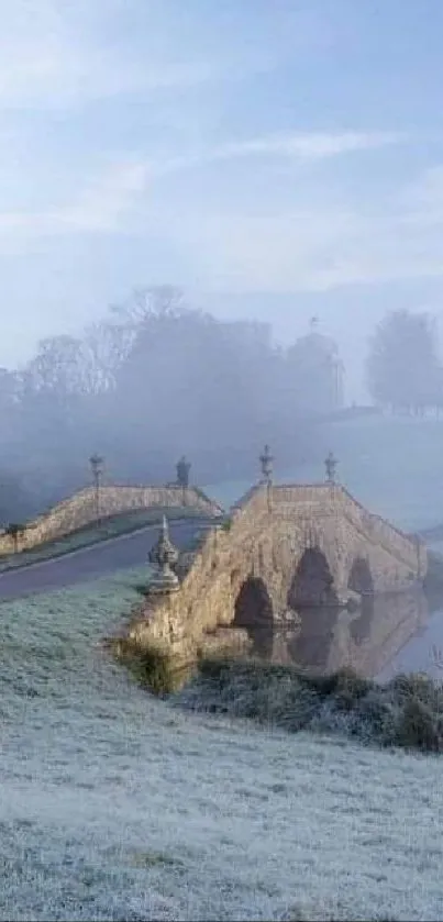 Stone bridge in a frosty, misty landscape with pale blue hues.