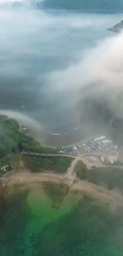 Aerial photo of a misty coastal landscape with lush greenery and calm waters.