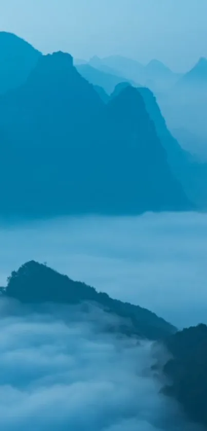 Misty blue mountain landscape wallpaper with fog and serene peaks.