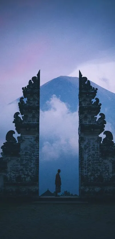 Misty mountain framed by ancient stone gates in tranquil landscape.