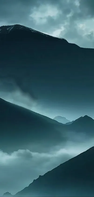 Misty mountain landscape with blue hues and clouds.