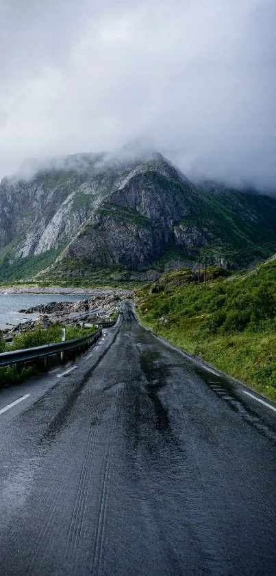 Misty road leading through mountainous landscape with foggy peaks.