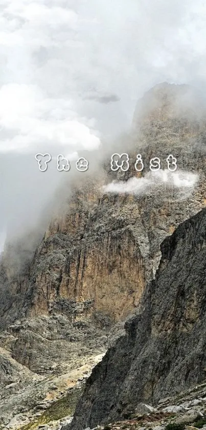 Misty mountain landscape with clouds enveloping rocky peaks.