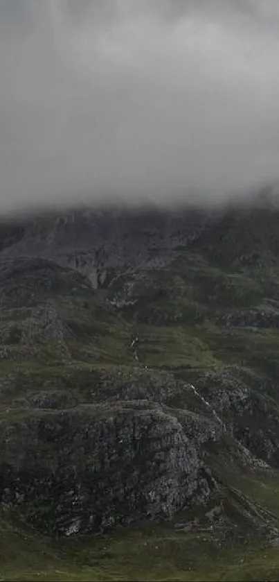 Misty mountain with green valleys and cloudy sky on phone wallpaper.