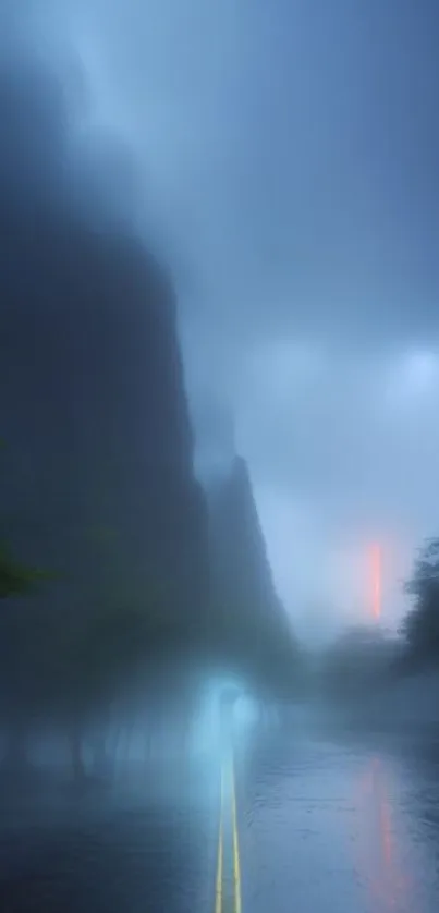 Misty road in a blue-hued foggy forest landscape.