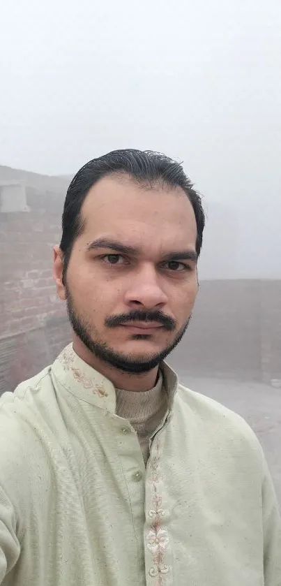 Misty morning rooftop selfie with foggy backdrop and a calm atmosphere.