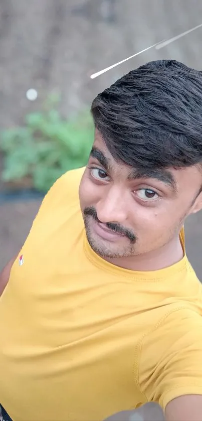 Smiling person in yellow shirt with outdoor background.