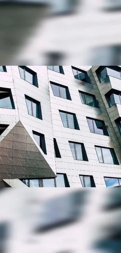 Geometric modern building facade with reflective windows.