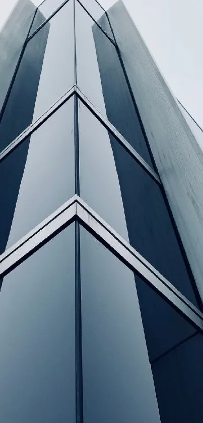 Modern skyscraper facade with geometric reflections in blue tones.