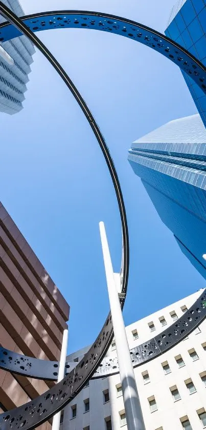 View of skyscrapers and geometric structure against a clear blue sky.