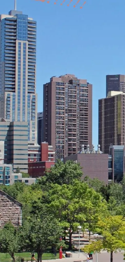 Vibrant city skyline with clear blue sky and lush green trees in the foreground.