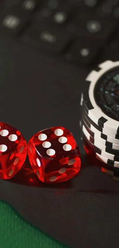 Red dice and poker chips on a green surface with keyboard backdrop.