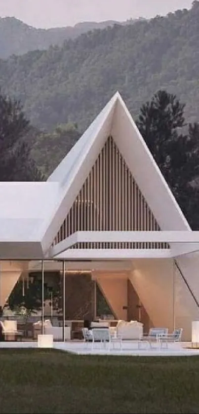 Modern A-frame house with mountains in the background.