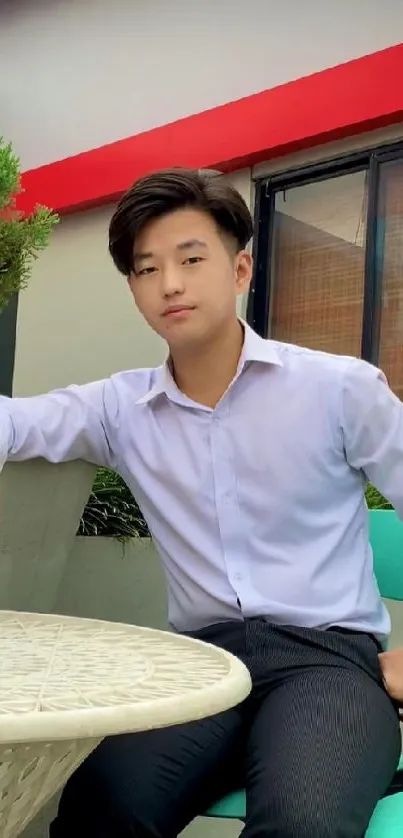 Stylish young man sitting outdoors, relaxing.