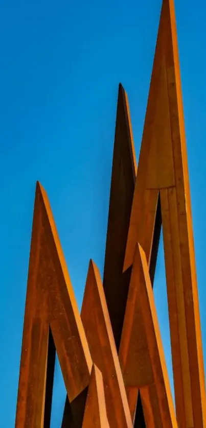 Modern rusty metal sculpture against blue sky.