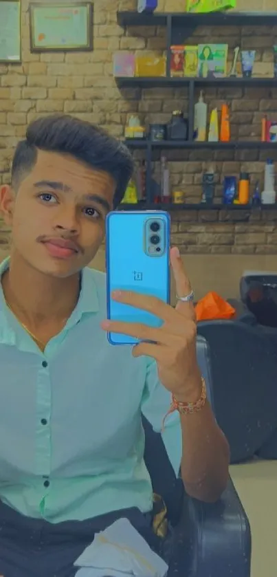 Young man takes a selfie in a modern salon with warm lighting.